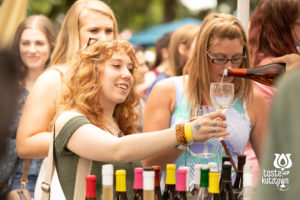 Wine vendor pouring wine sample for women at an outdoor wine & beer festival in Kutztown Pennsylvania