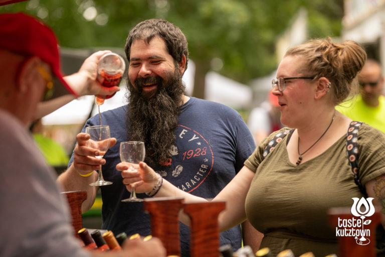 Wine vendor pouring wine sample for couple at an outdoor wine & beer festival in Kutztown Pennsylvania