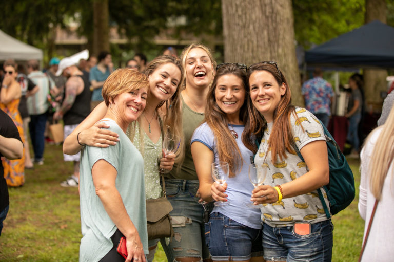 Group of women posing with wine glasses at an outdoor wine tasting festival in Kutztown Pennsylvania